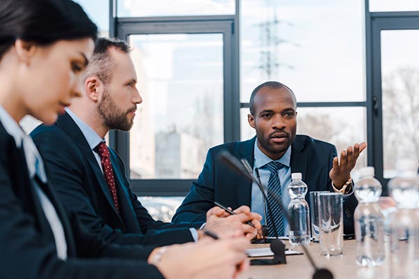 man leading a business meeting with two others present